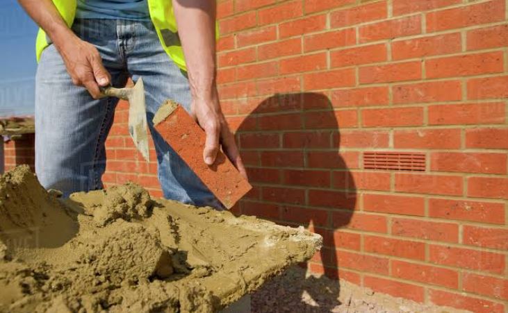 laying bricks with trowel